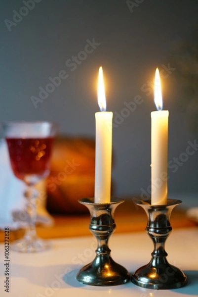 Fototapeta vertical photo Traditional challah bread with wine and glowing candles on dark background. Shabbat Shalom