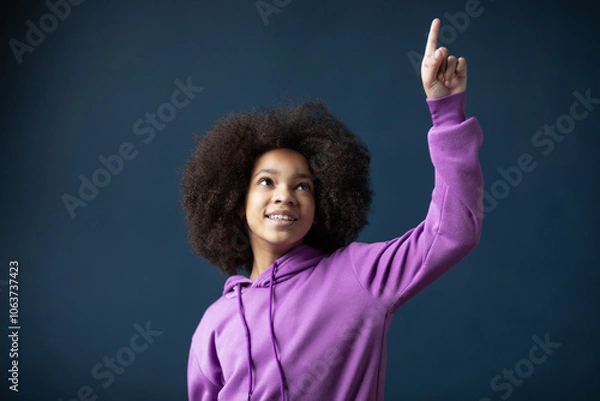 Obraz Portrait of optimistic confident girl look empty space finger up, leader's gaze wear violet sweater on blue color