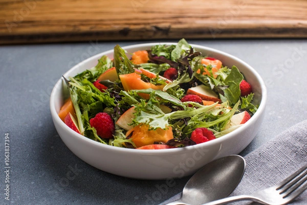 Fototapeta Fresh vegetable salad plate of  papaya, leaves raspberry and apple. Healthy food. Diet dinner or lunch menu. Salad plate on table. Flat lay.