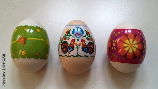 Fototapeta Three colorful Easter eggs on a white table