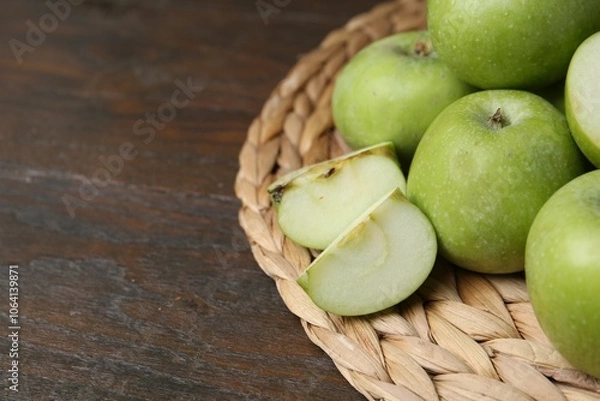 Fototapeta Whole and cut green apples on wooden table, closeup. Space for text