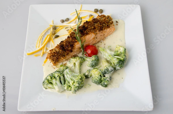 Obraz Fish breaded with nuts and broccoli in cream sauce.