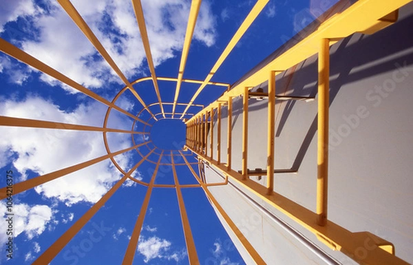 Fototapeta Looking up the inside of an enclosed industrial ladder