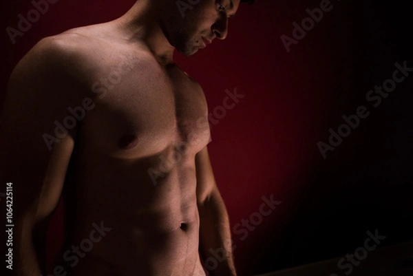Fototapeta busto nudo  maschile atletico a luci soffuse rosse