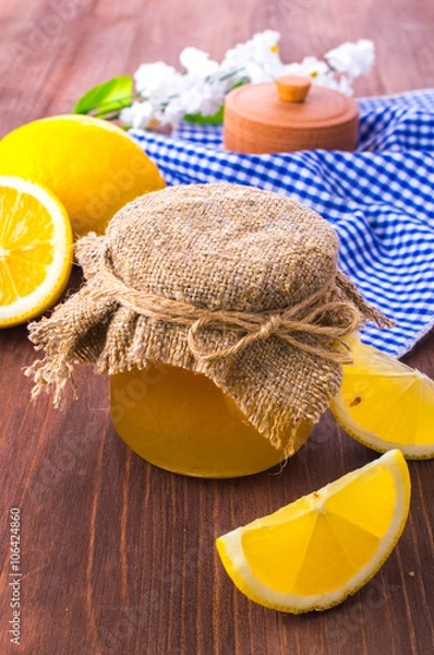 Obraz Honey comb, fresh lemon and a sprig of blossoms on a wooden table