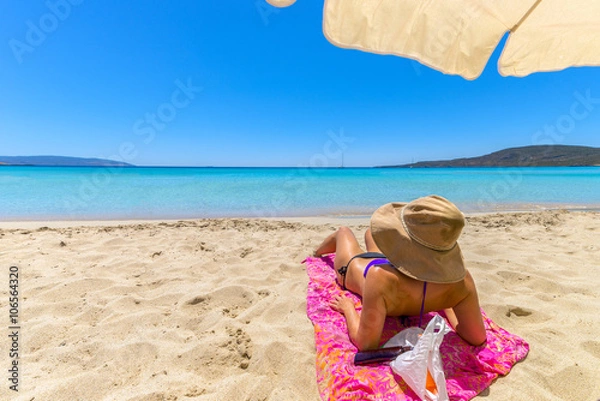 Fototapeta Beautiful young woman lying on the magnificent beach of Elafonis