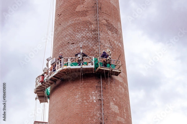 Obraz Industriekletterer reinigen einen Fabrikschornstein von Außen 