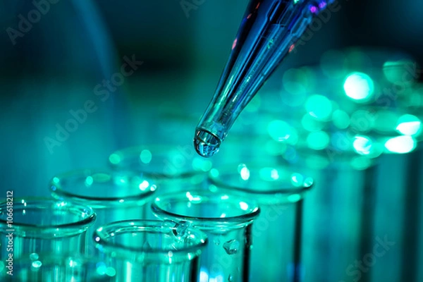 Fototapeta Pipette adding fluid to one of several test tubes