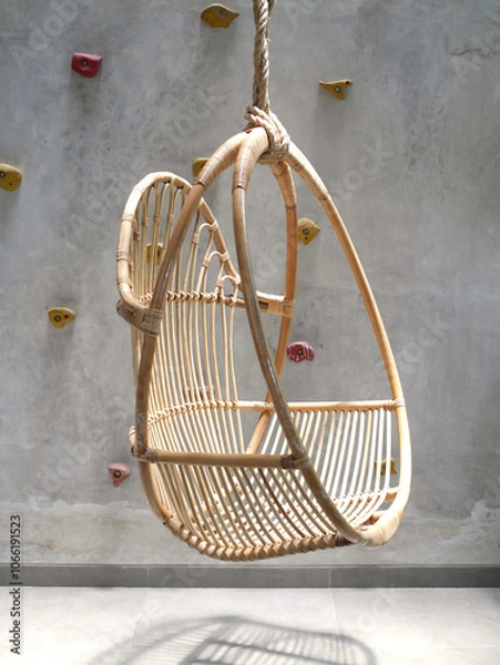 Fototapeta Industrial House Interior Showing Hanging Rattan Chair and Unfinished Wall With Colorful Climbing Points