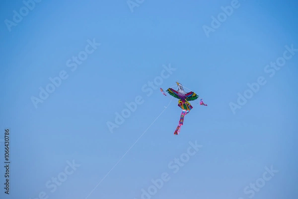 Fototapeta The dance of a eagle kite across the blue sky. Kite flying is a traditional Korean folk game enjoyed from Lunar New Year to Daeboreum, symbolizing sending away misfortune and welcoming fortune.	