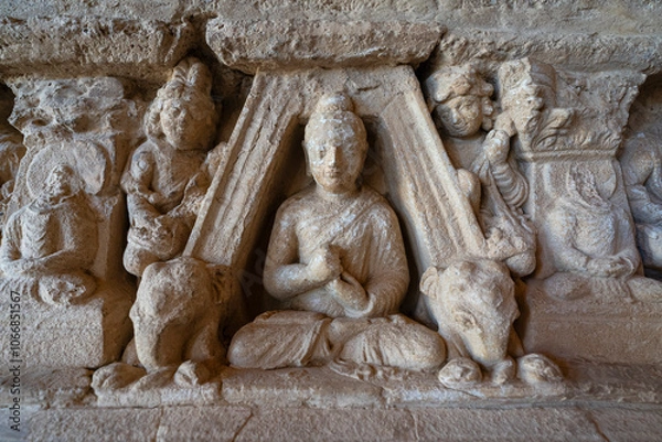 Obraz Closeup detail view of ancient stone carving with sitting Buddha and elephants on historic votive stupa, Jaulian monastery, Taxila, Pakistan