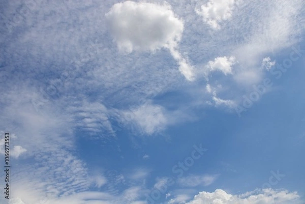 Fototapeta Beautiful daytime sky with scattered clouds over a serene landscape during mid-afternoon