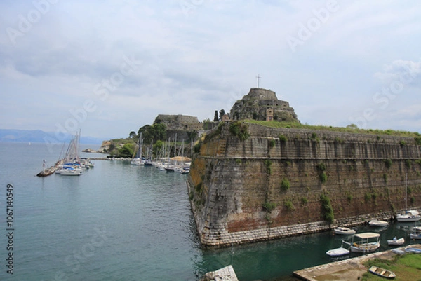 Fototapeta Fortress on the Sea Near a Greek Island: Historic Structure with a Cross on Top Overlooking the Ocean