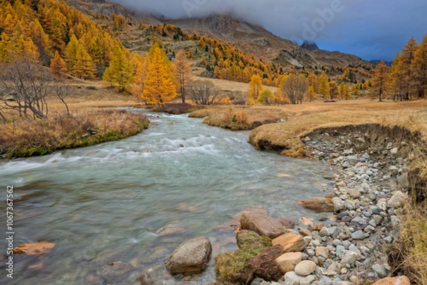 Fototapeta River in Clarée Valley on a cloudy morning at low-speed
