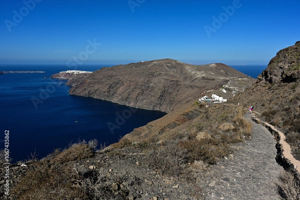 Obraz Ein Wanderweg führt entlang der Caldera der Griechischen Insel Santorin in Richtung der Stadt Oia. Der Caldera Wanderweg von Fira nach Oia ist der beliebteste Wanderweg auf der Insel.
