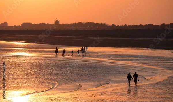 Fototapeta Beach at south end of Hayling island is turned golden by sunset
