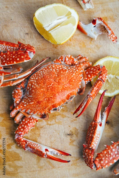 Fototapeta Crabs and lemon on wooden board