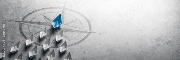 Fototapeta Blue Paper Boat Leading A Fleet Of Small White Boats With Compass Icon On Grey Concrete - Leadership Concept	
