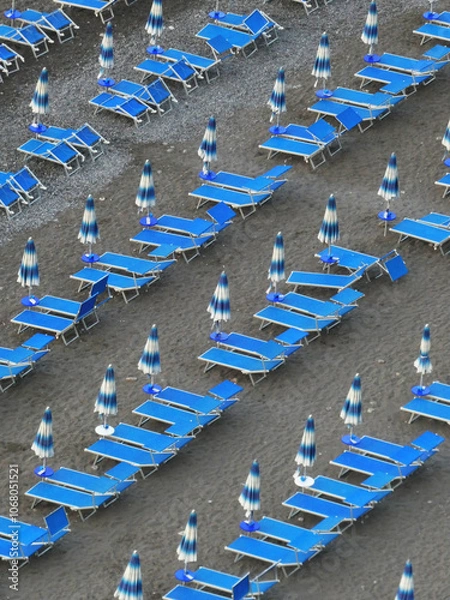 Fototapeta Beach chairs in a row on the beautiful Positano beach creates a repetitive pattern. On a peaceful quiet summers morning