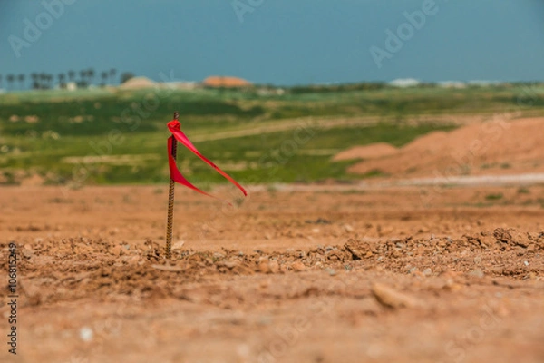 Obraz Metal survey peg with red flag on construction site