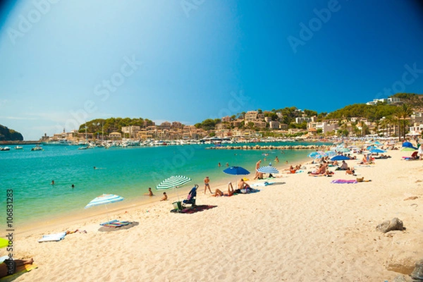 Obraz Colorful umbrellas on Puerto de Soller, Port of Mallorca island in balearic islands, Spain. Beautiful picture of people resting on the beach on bright summer day.