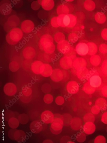 Fototapeta Red bokeh snowflakes background with soft blurred lights and shining particles, holiday