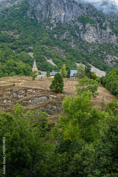 Fototapeta Church of Santa Eulalia de Unha with the Unha peak in the background. The town is located in the Aran valley, near Baqueira. Pyrenees Mountains, Spain