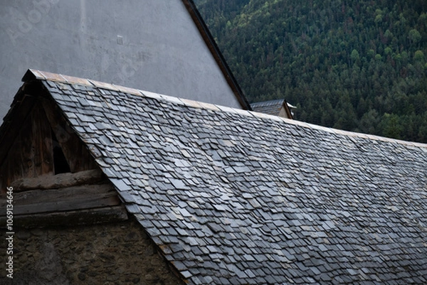 Fototapeta a black slate roof typical of the Baqueira region in the Pyrenees of Spain. Old stone houses prepared for the snow and cold of the area. Artisan manual construction