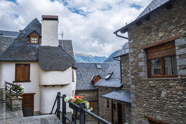 Fototapeta A small street in a typical town in the Pyrenees in Spain. The slate roofs and old stone houses protect from the cold and winter