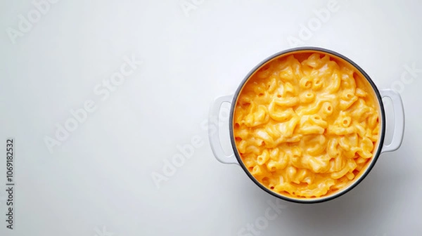 Fototapeta A pot of creamy macaroni and cheese on a plain background.
