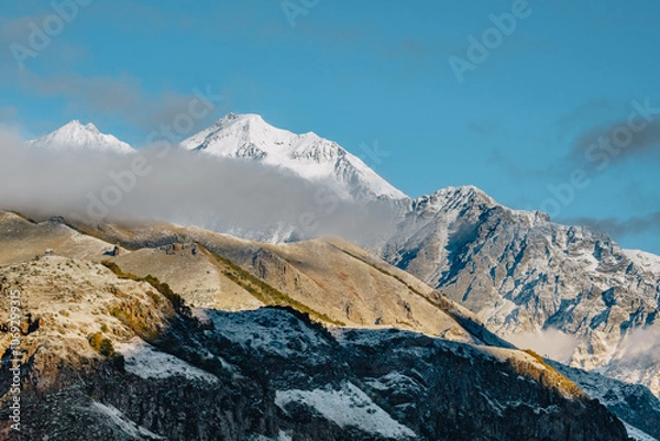 Obraz Snow covered mountains surrrounding the Stepantsminda village in the Kazbegi region of Georgia