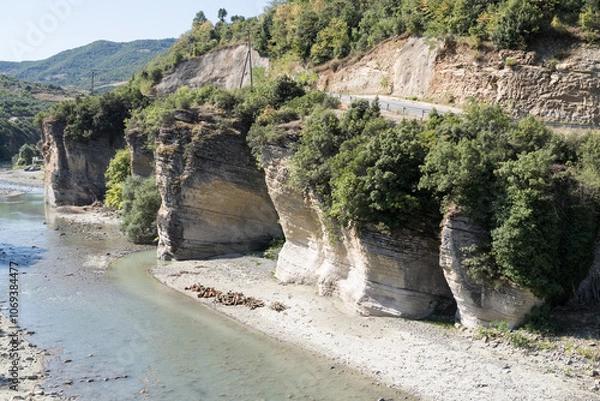 Fototapeta Corovoda, Albania - August 15 2024: Scenic view of the Osumi River canyon and connecting rugged shoreline from suspension foot bridge Corovode. 