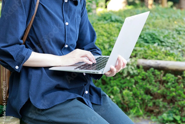 Obraz 公園でノートパソコンを使用している女性　屋外　仕事　イメージ