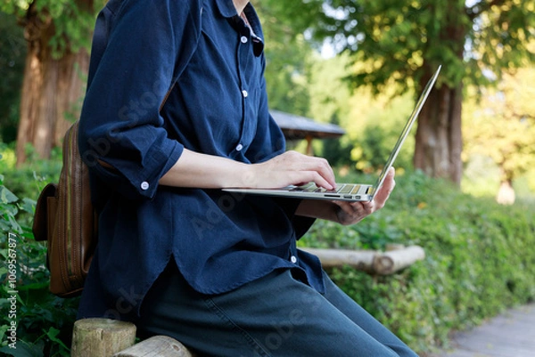 Fototapeta 公園でノートパソコンを使用している女性　屋外　仕事　イメージ