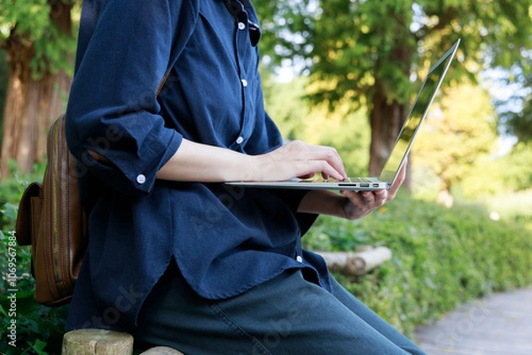 Obraz 公園でノートパソコンを使用している女性　屋外　仕事　イメージ