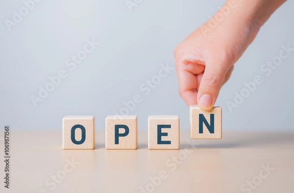 Fototapeta Hand-pick wooden cube blocks with OPEN words. A cafe, coffee shop, hotel, cafe restaurant, retail store, or online store is ready for service. The best service mind and business communication.