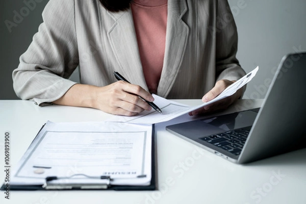Fototapeta Executive CEO businesswoman checking job applicant documents resumes, interviews, and signing to approve the contract in the office room