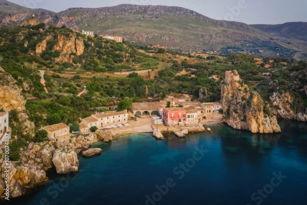 Fototapeta Wonderful Sights of The Stacks and Tonnara of Scopello Faraglioni e Vecchia Tonnara di Scopello , in Trapani Province, Sicily, Italy. June 2023, sunrise