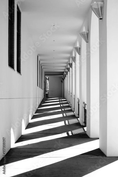 Obraz Schatten im schmalen Gang / Die Säulen und Pfeiler eines schmalen Ganges werfen Schatten.