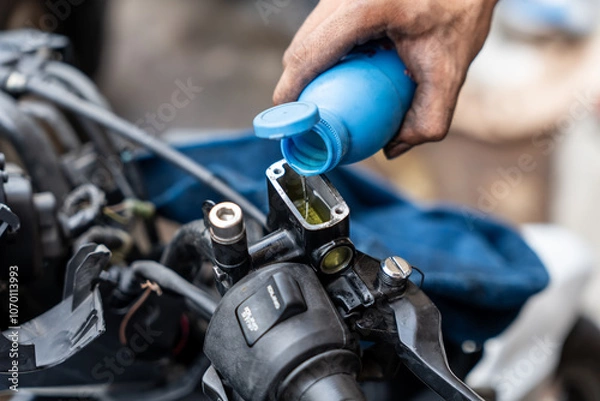 Obraz Mechanic check and Add Brake Fluid on motorcycle brake reservoir in garage, motorcycle repair concept