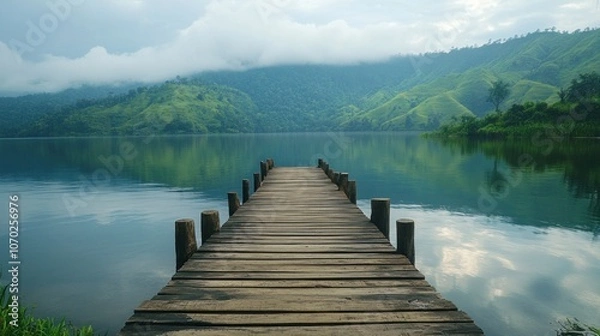 Fototapeta Wooden Dock Extending Into Tranquil Lake