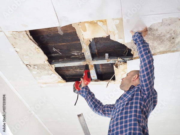 Fototapeta Man repairing collapsed ceiling