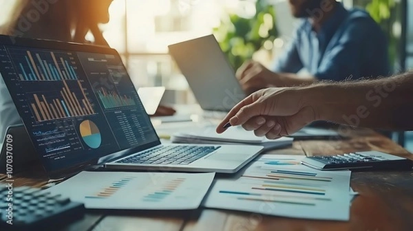 Fototapeta A business team analyzing financial data on laptop, Business team analyzing financial