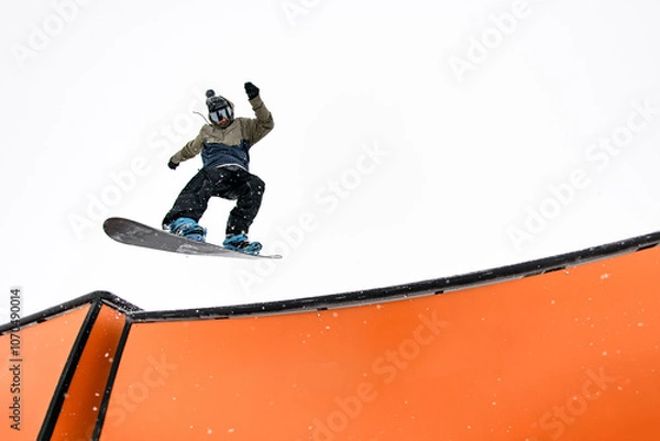 Fototapeta Snowboard pro executes jump into wallride, mastering challenging slope.