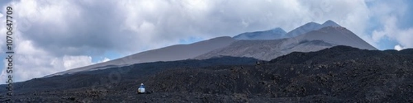 Fototapeta Tourist getting lost in  Mount Etna, active stratovolcano in Catania, Sicily region. It is one of the tallest active volcano in Europe. Travel and sightseeing journey concep. Panoramic view.
