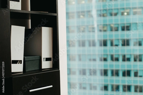 Obraz Office folders against the background of a skyscraper window.