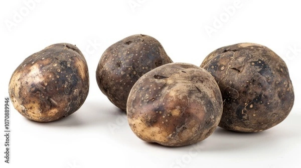 Fototapeta A group of potatoes sit on a white surface, awaiting processing or display