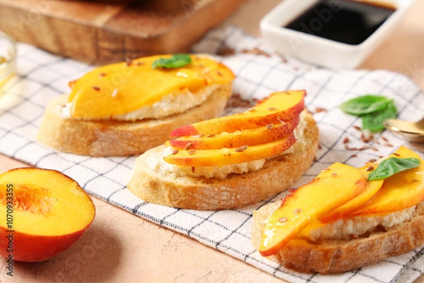 Fototapeta Peach bruschetta with ricotta, flax seeds and basil on beige background, closeup