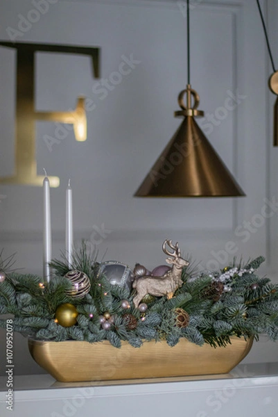Obraz Christmas table composition made of fresh nobilis spruce, white candles, pine branches with glass balls and decorative gold deer. Happy New Year decorations.