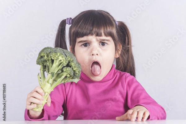 Obraz Little girl making a funny face refusing to eat her vegetables